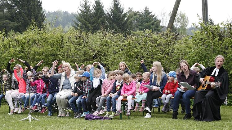 Den Festgottesdienst unter freiem Himmel, den Pfarrerin Sigrun Wagner (rechts) auf dem Gelände des Badesee unweit ihres Kinderhauses hielt, gestalteten die Jungen und Mädchen und das Betreuungsteam um Waltraut Bauer (Mitte) mit. Foto: Klaus Klaschka
