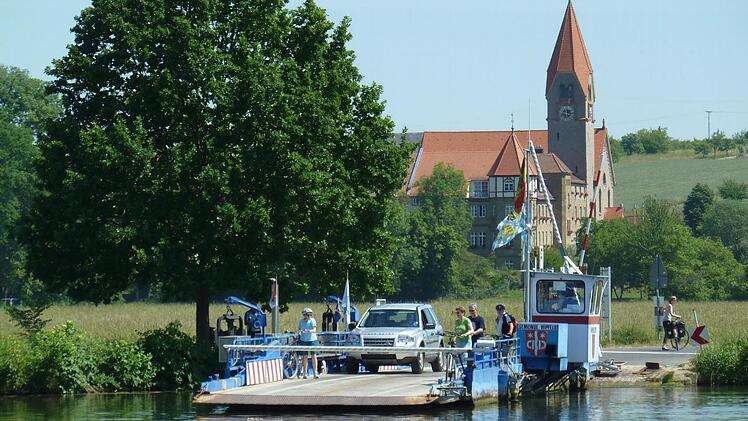 In nicht einmal zwei Minuten bringt die Fähre in Wipfeld (im Hintergrund der Ortsteil St. Ludwig) Fußgänger, Räder und Kraftfahrzeuge über den Main. Sie ist die größte Fähre in der Region. Die nächste Brücke ist hier 13 Kilometer entfernt. Foto: Matthias Litzlfelder