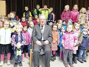 so lässt er sich am liebsten fotografieren: Josef Brandl inmitten vieler Kinder. Der Pfarrr wurde am Gründonnerstag 75 Jahre alt. Foto: Heidi Amon