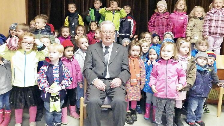 so lässt er sich am liebsten fotografieren: Josef Brandl inmitten vieler Kinder. Der Pfarrr wurde am Gründonnerstag 75 Jahre alt. Foto: Heidi Amon