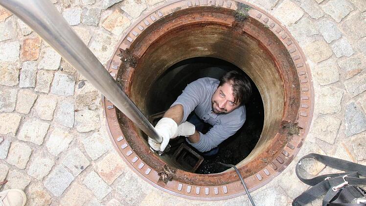 Student Werner Buchert steigt in den Schacht, um sich die Grundwasserregulierung von Bach- und Spitalgasse direkt vor Ort anzuschauen. Foto: Ralf Ruppert