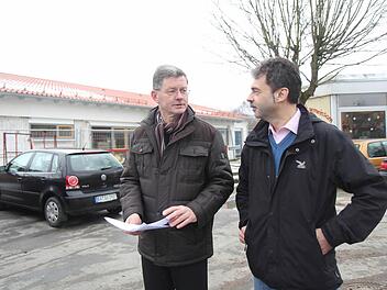 Bürgermeister Wolfgang Möhrlein (links) und Architekt Keller vor dem im Rohbau fertigen Neubau (links) der Kinderkrippe. Auf der etwa 270 Quadratmeter großen Satteldachhälfte sollte eine Photovoltaikanlage montiert werden. Rechts im Bild der Kindergarten-Altbau (mit Flachdach), der zum Teil abgebrochen werden soll.  Foto: Michael Gründel
