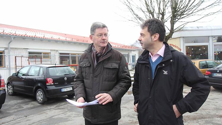 Bürgermeister Wolfgang Möhrlein (links) und Architekt Keller vor dem im Rohbau fertigen Neubau (links) der Kinderkrippe. Auf der etwa 270 Quadratmeter großen Satteldachhälfte sollte eine Photovoltaikanlage montiert werden. Rechts im Bild der Kindergarten-Altbau (mit Flachdach), der zum Teil abgebrochen werden soll.  Foto: Michael Gründel