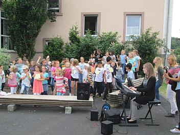 Die neuen Bänke im Pausenhof wurden in die Aufführung der Riedenberger Schüler integriert. Foto: Laura Mühlrath