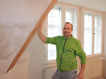 Ein altes Haus energetisch zu sanieren, ist aufwendig: Um historische Fenster zu erhalten, mussten in diesem Baudenkmal zusätzliche Fenster innen eingebaut werden. Auf dem Bild verkleidet Malermeister Tino Kickuth die frisch gedämmten Gauben.