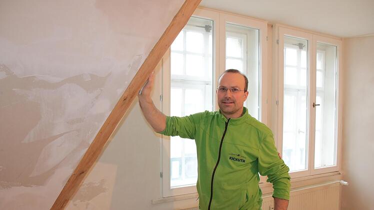 Ein altes Haus energetisch zu sanieren, ist aufwendig: Um historische Fenster zu erhalten, mussten in diesem Baudenkmal zusätzliche Fenster innen eingebaut werden. Auf dem Bild verkleidet Malermeister Tino Kickuth die frisch gedämmten Gauben.