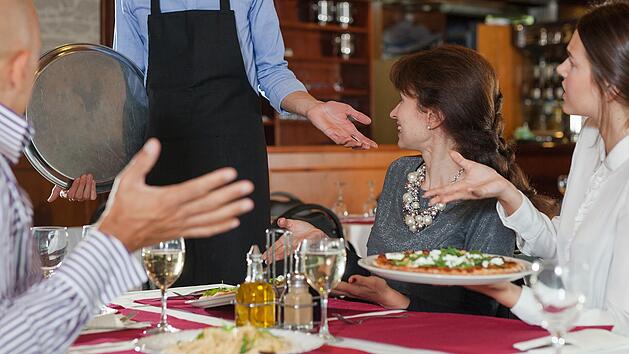 Unzufriedene Gäste reklamieren im Restaurant beim Kellner