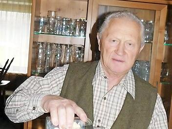 Der Jubilar füllt ein Schnapsglas mit einem Destillat aus seiner Brennerei. Foto: Horst Wunner