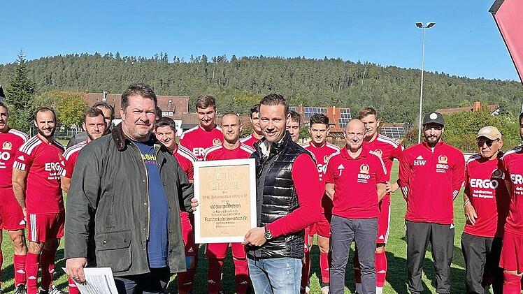 Nachträglich zum 100. Jubiläum, das der VfR Johannisthal 2020 hätte feiern können, überbrachte der BLSV-Kreisvorsitzende Mario Schmid (vorne links) die Ehrenurkunde und gratulierte zum Jubiläum. Die Ehrenurkunde nahm Vorsitzender Marc Bergauer (vorne rechts) mit Dank entgegen. Im Hintergrund die Spieler der Ersten Fußballmannschaft des VfR Johannisthal.