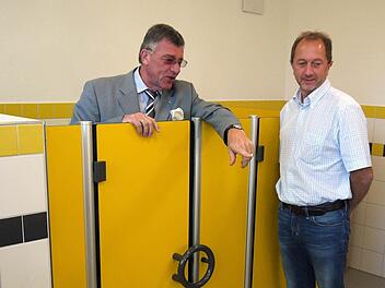 Gelbe Türen im Kindergarten Tigerente: Bürgermeister Gerhard Preß (links) und Bauamtsleiter Günter Benning besichtigen die Sanitäranlagen. Fotos: Berthold Köhler