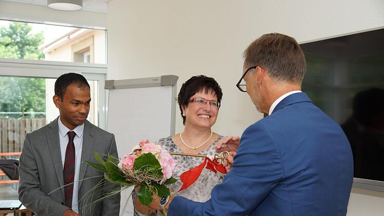 Stefan Richter (rechts) überreicht Patricia Schießer und Pater Sony Kochumalayil den symbolischen Schlüssel. Foto: Arkadius Guzy