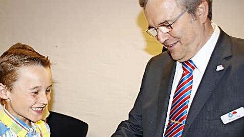 Freudestrahlend nimmt Jamin Deschner aus Eggolsheim die Glückwünsche von Raiffeisen-Vorstand Rainer Lang entgegen.