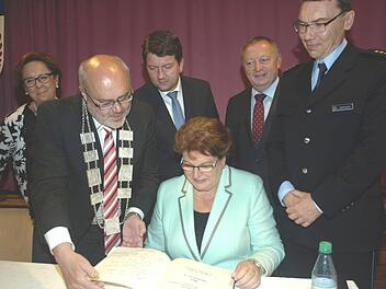 Barbara Stamm trägt sich in das Goldene Buch der Gemeinde Oerlenbach ein. Mit dabei (von links) Bezirksrätin Karin Renner, Bürgermeister Franz Kuhn, MdL Sandro Kirchner, Frank Schaffrath-Schürmann als Leiter der Schule des BPOLAFZ, Landrat Thomas Bold und der Leiter des BPOLAFZ, Thomas Lehmann.  Foto: Stefan Geiger