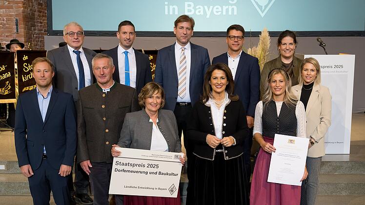 Eine Gruppe von Menschen posiert mit Landwirtschaftsministerin Michaela Kaniber auf einer Treppe.