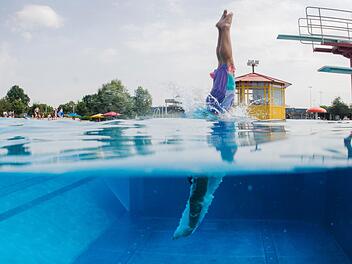 Schwimmer springt vom Sprungturm ins Wasser