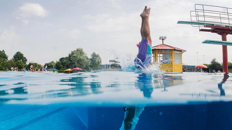 Schwimmer springt vom Sprungturm ins Wasser