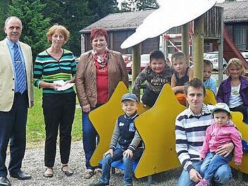 Kinderschar können sich auf dem Mannsflurer Spielplatz in der Ortsmitte wieder nach Herzenslust austoben. Im Bild (von links) Bürgermeister Franz Uome mit Sabine Müller und Erna Lauterbach sowie Leon (unten links sitzend) im Kreise der Spielkameraden.  Foto: Klaus-Peter Wulf