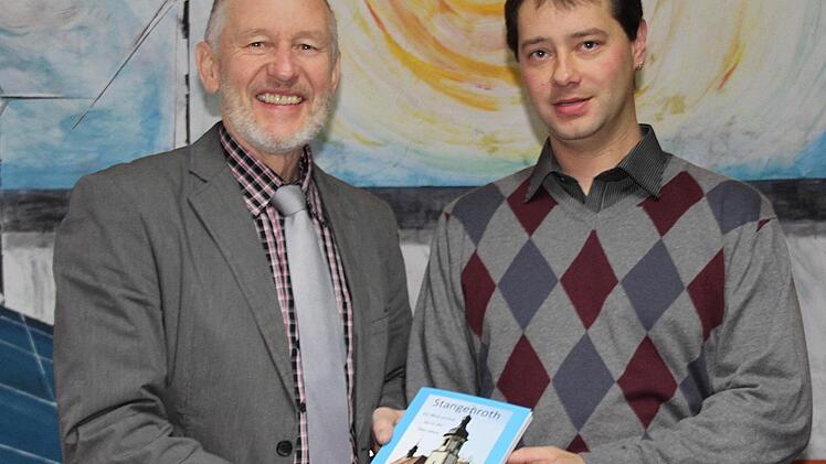 Vereinsringsvorsitzender Andr&eacute; Ke&szlig;ler (rechts) &uuml;berreicht B&uuml;rgermeister Waldemar Bug (links) die Chronik "Stangenroth - ein Blick zur&uuml;ck bis in die 70er Jahre". Foto: Ernst Dettmer