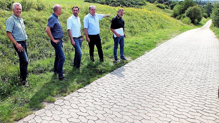 Der Sander Bürgermeister Bernhard Ruß (2.von rechts) zeigt (weiter von links) Wasserwart Wolfgang Thein, seinen Amtskollegen Stefan Paulus und Holger Baunacher sowie Planungs-Ing. Günter Englert, wo die Hauptwasserleitung entlang des Stückäckerweges an Sand vorbei bis zum Übergabeschacht in der Talsenke vorbei geführt werden kann. Foto: Alfons Beuerlein