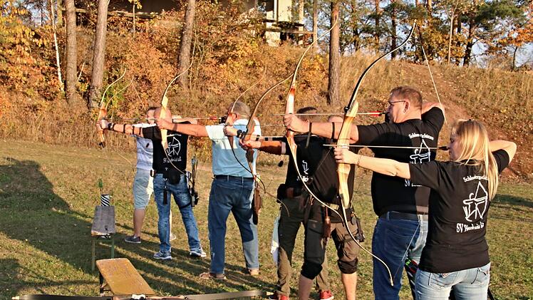 Vorsitzende Yvonne Leidner (rechts) spannt die Pfeilsehne mit ihren sechs männlichen Trainingsteilnehmern. Helmut Will