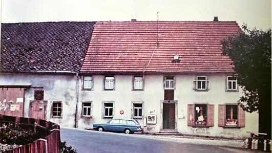 Ein Bild aus den 1970er-Jahren, kurz vor Abriss des (rechten) Hauses zum Bau der Schlossstraße, in dem der Gemischtwarenladen beheimatet war. Bis 1891 war dort die Krugbäckerei. Heute ist der Gemischtwarenladen von Helma Betz an der Stelle der linken Scheune.