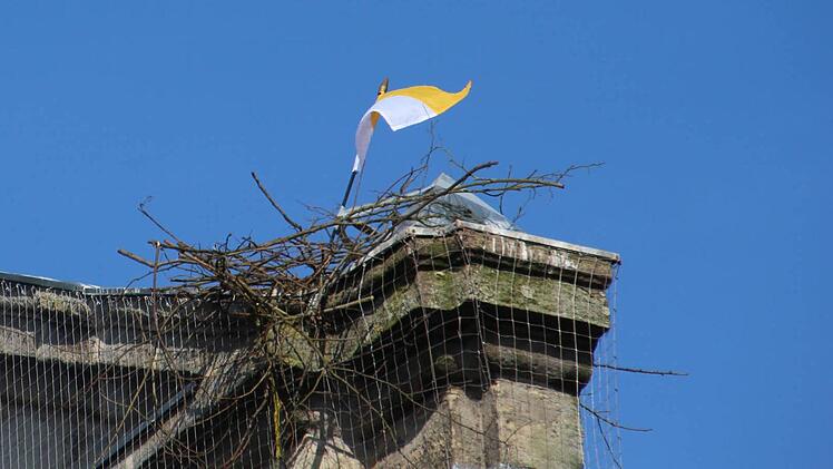 Eine Fahne soll den Storch am Weiterbau auf der Kirchenfassade hindern. Foto: Andreas Dorsch