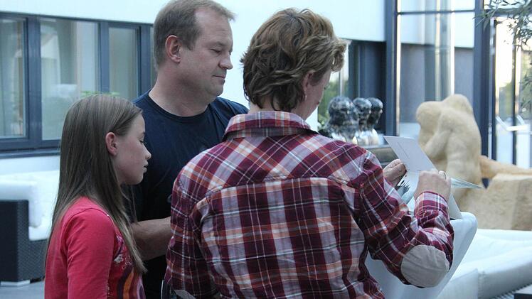 Tobias Peter und seine Familie suchen ihr Bild im Kalender. Foto: Lena Alt