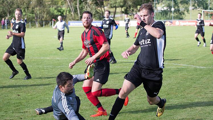 SG-Keeper Philipp Greiner ist rechtzeitig aus seinem Kasten und fängt den Ball vom dreifachen Unterrodacher Torschützen Florian Erhardt (schwarzes Trikot) ab.  Foto: Heinrich Weiß