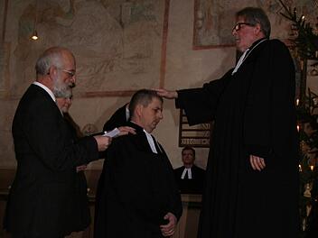 Dekan Jürgen Zinck (rechts) legt dem neuen Pressecker Pfarrer Siegfried Welsch, der gestern in einem Gottesdienst in sein Amt eingeführt wurde, die Hand auf. Links ist der Vertrauensmann aus Lichtenberg, Helmuth Mauer, zu sehen. Fotos: Sonja Adam