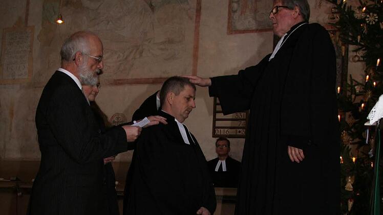 Dekan Jürgen Zinck (rechts) legt dem neuen Pressecker Pfarrer Siegfried Welsch, der gestern in einem Gottesdienst in sein Amt eingeführt wurde, die Hand auf. Links ist der Vertrauensmann aus Lichtenberg, Helmuth Mauer, zu sehen. Fotos: Sonja Adam