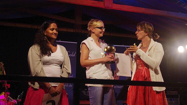Die scheidende Weinkönigin Sonja Schmiedel (rechts) überreicht ihrer Nachfolgerin Daniela Krüger (Mitte) den Weinpokal und die Weinkrone. Mit auf dem Bild ist (links) die Weinprinzessin Jana Schmidt.