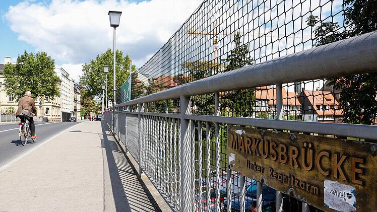 An der Markusbrücke hängt seit Montag ein Netz. Es soll Besucher der Sandkerwa in Bamberg, die unter der Brücke stehen, vor herunterfallenden Gegenständen schützen. Es ist eine der zahlreichen Neuerungen, die im neuen Sicherheitskonzept festgeschrieben sind.  Foto: Matthias Hoch