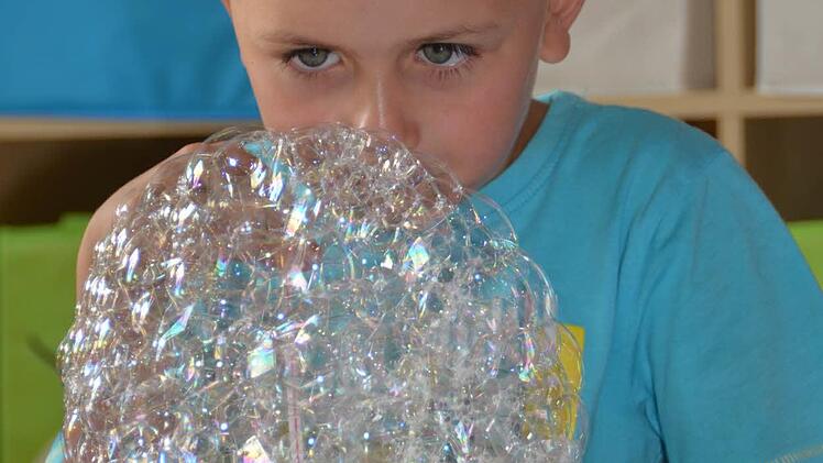 Luca sitzt hier vor einem Seifenblasenberg. Foto: Kathrin Kupka-Hahn