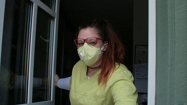 Kontakt über das Fenster: Medizinische Fachangestellte Marina Meier reicht Unterlagen heraus, damit Patienten nicht die Praxisräume betreten müssen. Foto: Jürgen Gärtner