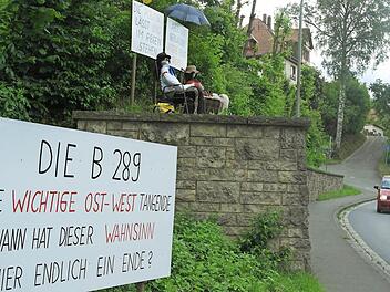Das Plakat über den beiden Figuren, die die Kauerndorfer an der Ortsdurchfahrt der B 289 gegenüber der Einmündung nach Fölschnitz aufgestellt haben, passt zum Wetter: "Die Politik lässt uns im Regen stehen." Erst seit Dienstag steht das große Transparent unten. Fotos: Peter Müller