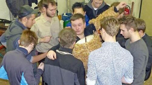 Bis zu zehn Jungs helfen mit, um die "Berta" in ihr Strohkostüm zu schnüren.