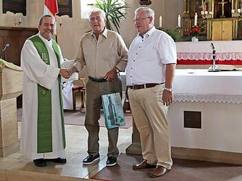 Pfarrer Alfred Beißer und Pfarrgemeinderatsvorsitzender Konrad Ochs (r.) verabschiedeten Johann Galster, der 65 Jahre als Organist tätig war. Foto: Franz Galster