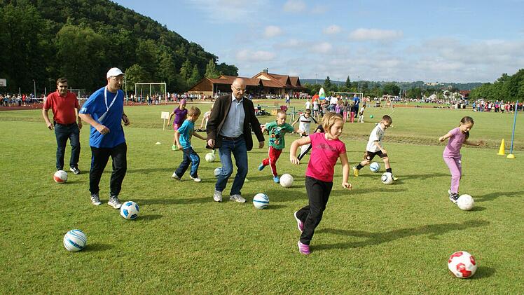 Dribbeln und auf Kommando Richtung Tor: an der Fußball-Station eröffneten die beiden Schirmherren Landrat Wilhelm Schneider (Bildmitte) und Bürgermeister Walter Ziegler (links) den Sporttag "Franken Aktiv" des BLSV. Fotos: Sabine Weinbeer