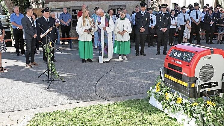 Pfarrer Hans Hübner segnet im Beisein vieler Gäste die neue Feuerwehrpumpe von Hohenhäusling.