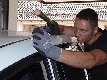 Oliver Otto beseitigt mit einer speziellen Technik Dellen und Beulen oder Kratzer aus Autokarosserien. Foto: Rainer Lutz