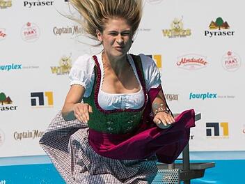 Da geht ein Playmate baden - Lea Götz aus Franken wagt mit Dirndl den Sprung ins kühle Nass. Foto: Daniel Karmann, dpa