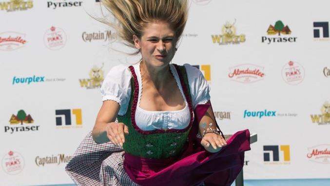 Da geht ein Playmate baden - Lea Götz aus Franken wagt mit Dirndl den Sprung ins kühle Nass. Foto: Daniel Karmann, dpa