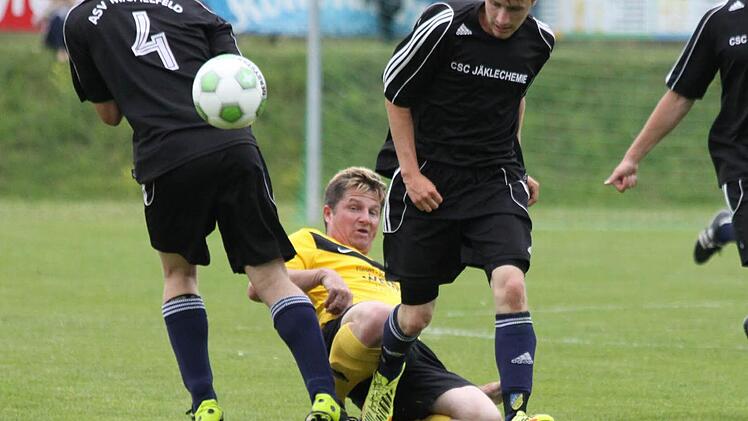 Kirchenbirkigs Spielertrainer Thomas Riess (gelbes Trikot) bleibt an der jungen Michelfelder Abwehr hängen. Foto: Uwe Kellner