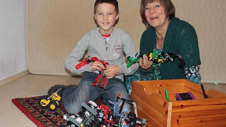 Im Kinderzimmer: Tim und seine Tagesmutter Monika Wick spielen mit Lego.  Foto: Sabine Herteux