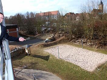 Die Realschule Ebern platzt aus allen Nähten. Es fehlen Klassenzimmer und weitere Räume. Realschulrektor Hartmut Weis war schon Anfang des Jahres der Meinung, dass ein Anbau unausweichlich ist. Günstigste Variante ist nach seiner Einschätzung ein Anbau im Westen Richtung Bahndamm. Vom Fenster eines Unterrichtsraumes aus zeigt er am Donnerstag auf die Fläche. Im Hintergrund ist links das alte Hallenbad zu sehen.  Foto: Michael Will