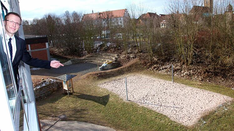 Die Realschule Ebern platzt aus allen Nähten. Es fehlen Klassenzimmer und weitere Räume. Realschulrektor Hartmut Weis war schon Anfang des Jahres der Meinung, dass ein Anbau unausweichlich ist. Günstigste Variante ist nach seiner Einschätzung ein Anbau im Westen Richtung Bahndamm. Vom Fenster eines Unterrichtsraumes aus zeigt er am Donnerstag auf die Fläche. Im Hintergrund ist links das alte Hallenbad zu sehen.  Foto: Michael Will