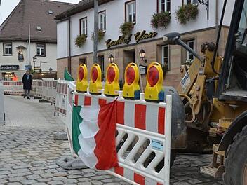 Geduldig und mit Humor haben die Betreiber der Osteria (ehemals Gasthaus Glass) die Baustelle begleitet und die Absperrung mit Fahnen geschmückt.     Foto: Bernhard Panzer