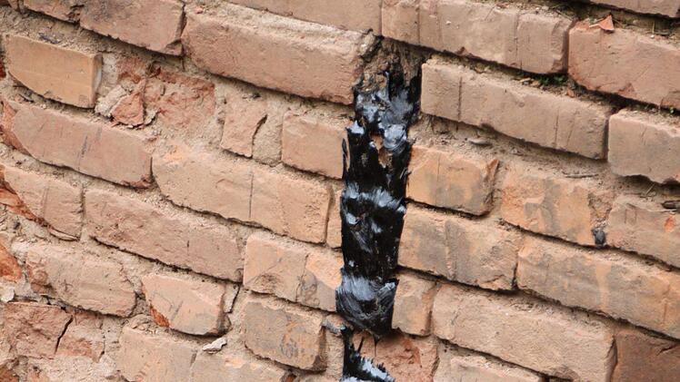 Teer läuft aus der Mauer einer alten Zisterne. Foto: Ulrike Müller