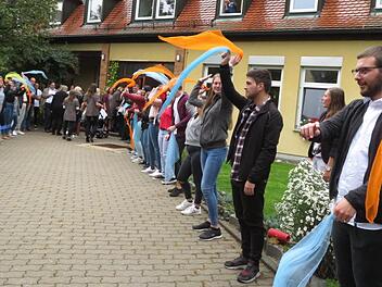 Mit bunten Tüchern standen die 38 Berufsfachschüler für Kinderpflege Spalier für die Gäste der Jubiläumsfeier. Foto: Monika Schütz