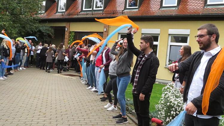 Mit bunten Tüchern standen die 38 Berufsfachschüler für Kinderpflege Spalier für die Gäste der Jubiläumsfeier. Foto: Monika Schütz
